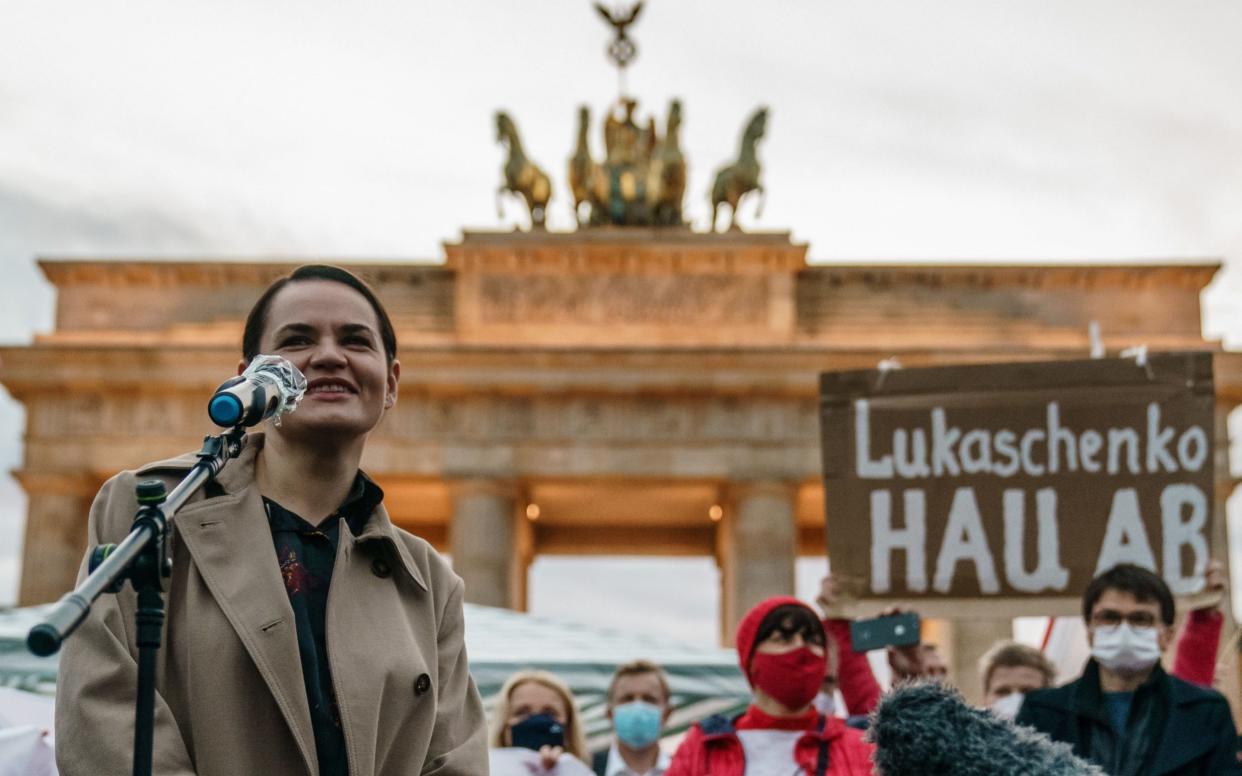 Mandatory Credit: Photo by CLEMENS BILAN/EPA-EFE/Shutterstock (10913046ak) Belarusian opposition leader Sviatlana Tsikhanouskaya (L) speaks during a protest against the political situation in Belarus, as a protesters raises a cardboard reading 'Lukashenko get lost' (R), referring to Belarusian President Lukashenko, in front of the Brandenburg Gate in Berlin, Germany, 05 October 2020.Tsikhanouskaya is on a visit to Berlin for a meeting with German Chancellor Merkel scheduled for 06 October 2020. Belarusian opposition leader Sviatlana Tsikhanouskaya visits Berlin, Germany - 05 Oct 2020 - CLEMENS BILAN/EPA-EFE/Shutterstock