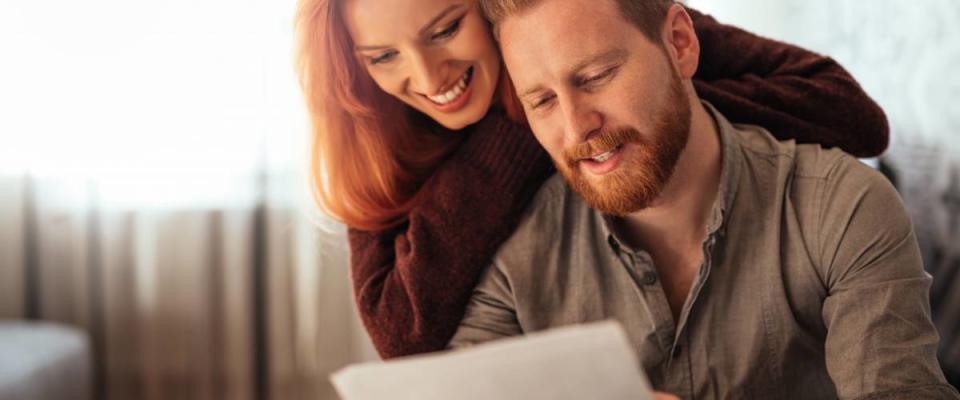 happy couple smiling while looking at a file