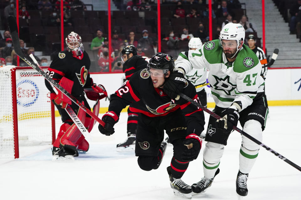 Ottawa Senators' Thomas Chabot (72) gets a push from Dallas Stars' Alexander Radulov (47) during first-period NHL hockey game action in Ottawa, Ontario, Sunday, Oct. 17, 2021. (Sean Kilpatrick/The Canadian Press via AP)