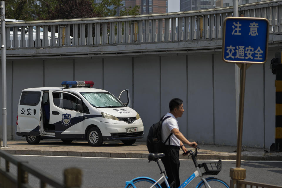 A man pushes a bicycle past by a police van stationed at a bridge along the Chang'an Avenue in Beijing, Tuesday, June 4, 2024. China has quashed large-scale commemorations of Tuesday's 35th anniversary of Beijing's Tiananmen Square crackdown within its borders. But outside the country, commemorative events have grown increasingly crucial for preserving memories of the 1989 bloodletting, in which government troops opened fire on pro-democracy protesters resulting in hundreds, if not thousands, dead. (AP Photo/Andy Wong)