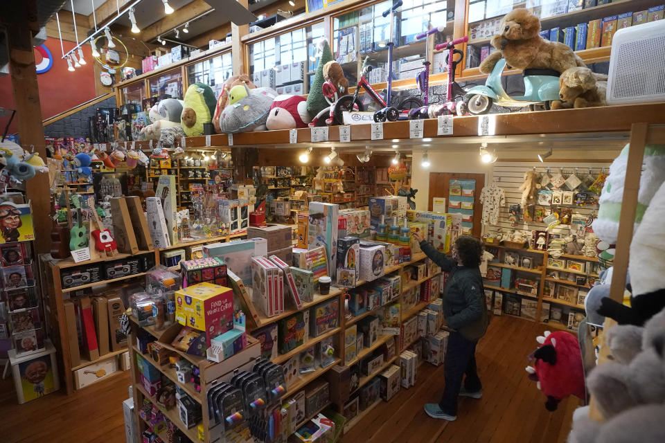 Customers shop at a Five Little Monkeys store in Berkeley, Calif., Monday, Dec. 12, 2022. Small retailers say this year looks much different than the last "normal" pre-pandemic holiday shopping season of 2019. They're facing decades-high inflation forcing them to raise prices and making shoppers rein in the freewheeling spending seen in 2021 when they were flush with pandemic aid and eager to spend. (AP Photo/Jeff Chiu)