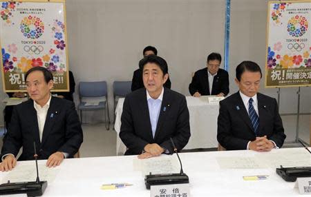 Japan's Prime Minister Shinzo Abe (C), flanked by Chief Cabinet Secretary Yoshihide Suga (L) and Finance Minister Taro Aso, speaks about Tokyo's successful bid to host the 2020 Summer Olympics and Paralympics after returning from Buenos Aires, Argentina, during a cabinet meeting at the prime minister's official residence in Tokyo September 10, 2013. REUTERS/Itsuo Inouye/Pool