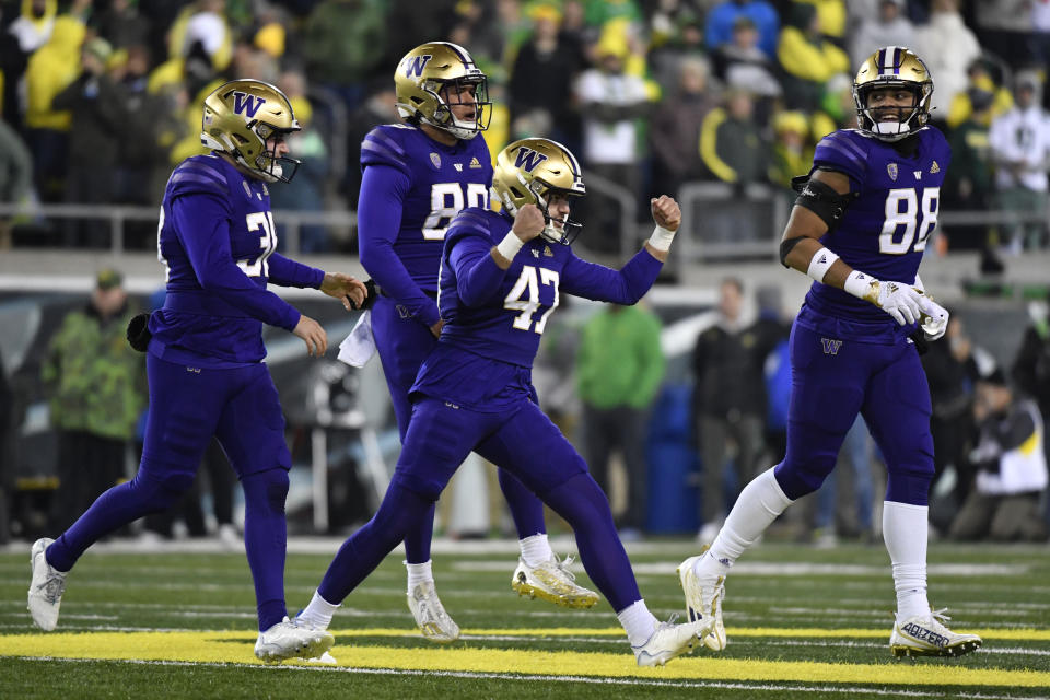 Washington placekicker Peyton Henry (47) celebrates ith punter Jack McCallister (38), tight end Quentin Moore (88) and long snapper Jaden Green (89) after making a field goal during the second half of an NCAA college football game against Oregon, Saturday, Nov. 12, 2022, in Eugene, Ore. (AP Photo/Andy Nelson)