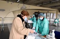 FILE PHOTO: Medical workers wearing protective masks check patients at a medical checkpoint at the entrance of the Spedali Civili hospital in Brescia