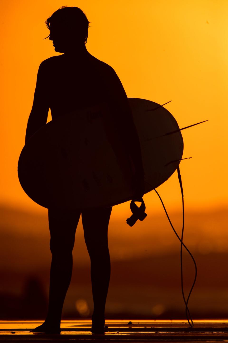 A surfer watches the sunrise from JP Luby Beach in Corpus Christi on Thursday, Sept. 29, 2022.