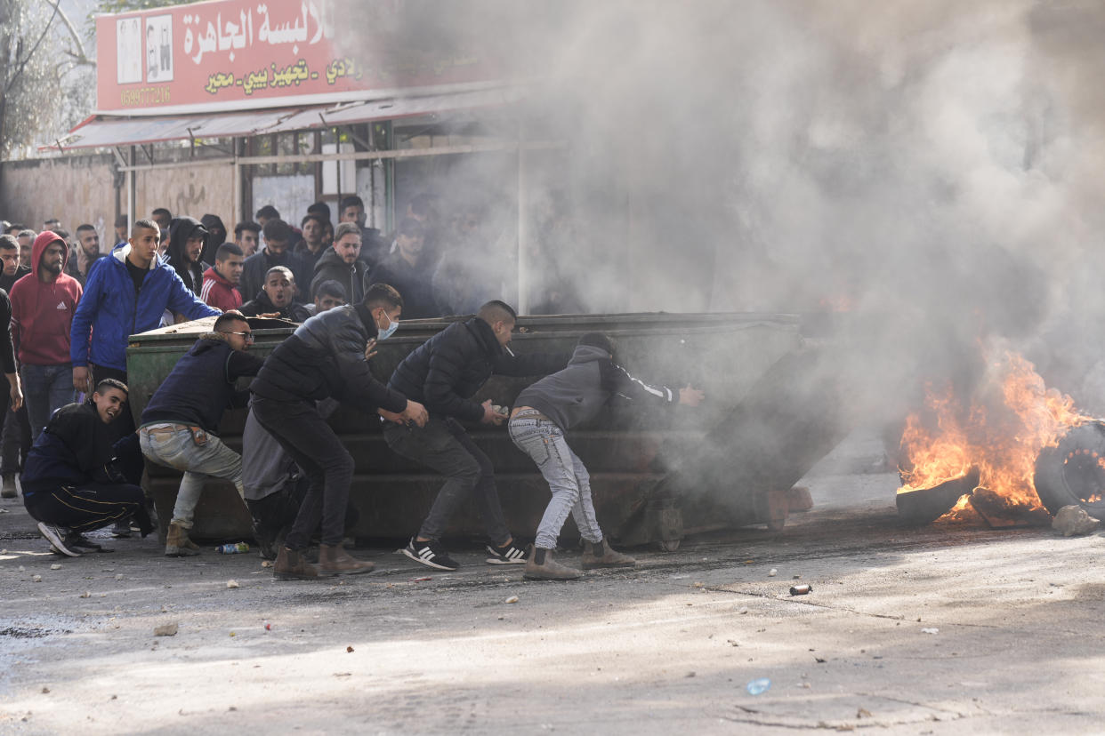 Palestinians clash with Israeli forces following an army raid in the West Bank city of Jenin, Thursday, Jan. 26, 2023. Israeli forces killed at least nine Palestinians, including a 60-year-old woman, and wounded several others during a raid in a flashpoint area of the occupied West Bank on Thursday, Palestinian health officials said, in one of the deadliest days in months of unrest. The Israeli military said it was conducting an operation to arrest a militant grouping linked to the Palestinian Islamic Jihad, which has major foothold in the camp. A gun battle erupted, during which the military said it was targeting militants involved in planning and carrying out attacks on Israelis. (AP Photo/Majdi Mohammed)