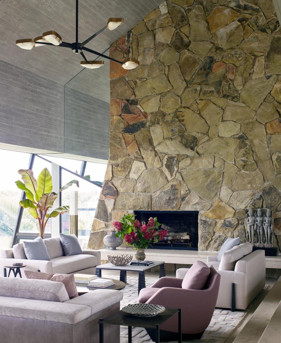 In the sunken living room, which is part of a vast open space with ceilings that rise up to 30 feet, Moon created a set of side-by-side parlors. “It’s a very angular house, and I felt it needed a softer edge,” says the designer about the soothing color palette, largely inspired by the seascape surrounding the house. Right next to the fireplace, he placed two oyster-hued loveseats with wraparound ebonized legs. The Jean de Merry coffee table between them has bronze legs and a shagreen leather top. In the forefront we see a curvaceous armchair by Georgis & Mirgorodsky for Maison Gerard.