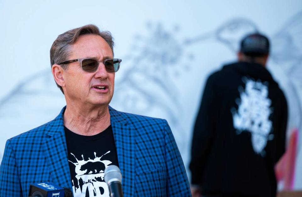 Wide Open Walls CEO David Sobon speaks at a kick off event for the 2022 festival in East Sacramento as artist Christian Garcia of Los Angeles sketches out a temporary mural behind him. Hector Amezcua/Sacramento Bee file