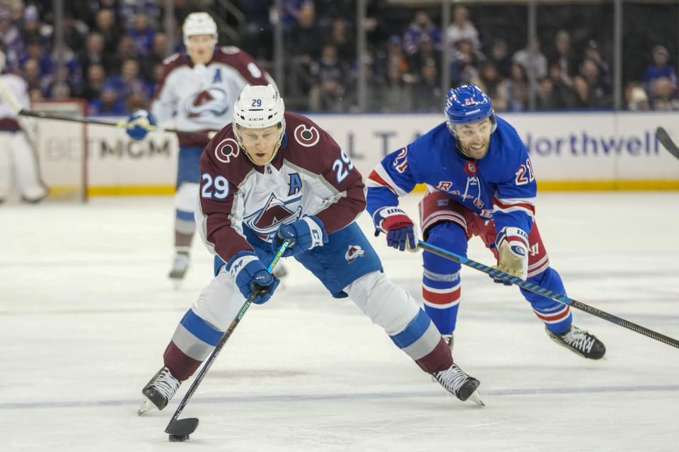 Colorado Avalanche center Nathan MacKinnon (29) controls the puck ahead of New York Rangers center Barclay Goodrow (21) during the first period of an NHL hockey game, Monday, Feb. 5, 2024, at Madison Square Garden in New York. (AP Photo/Mary Altaffer)