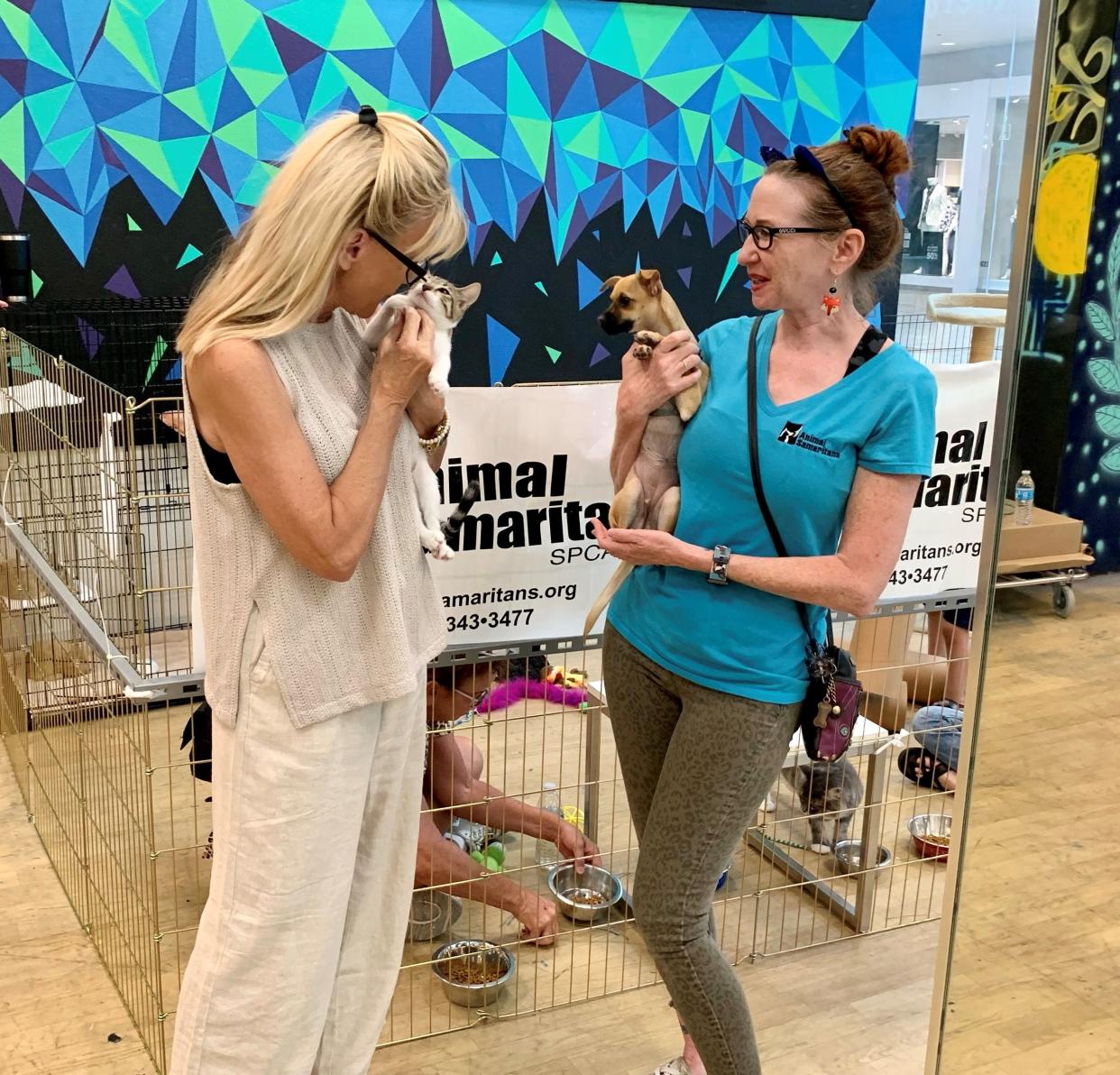 Sandie Newton and Valerie Kattz admire tiny animals at an adoption event at the Shops at Palm Desert.