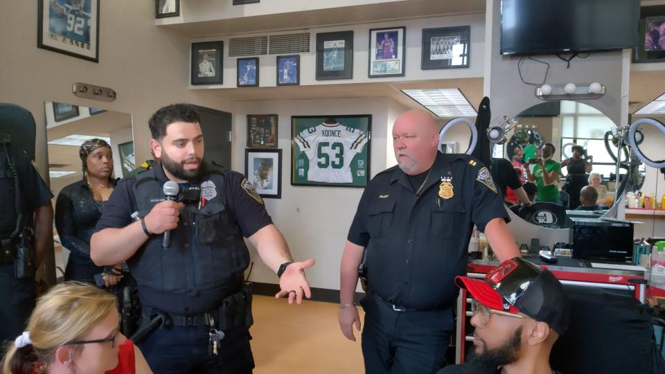 Officer Salah Al-zalloum and Patrick Pajot of the Second Police District meet with residents and youth at Gee's Clippers on Dr. Martin Luther King Drive on May 31, 2023 to open dialogue they hope with bridge gaps between them.