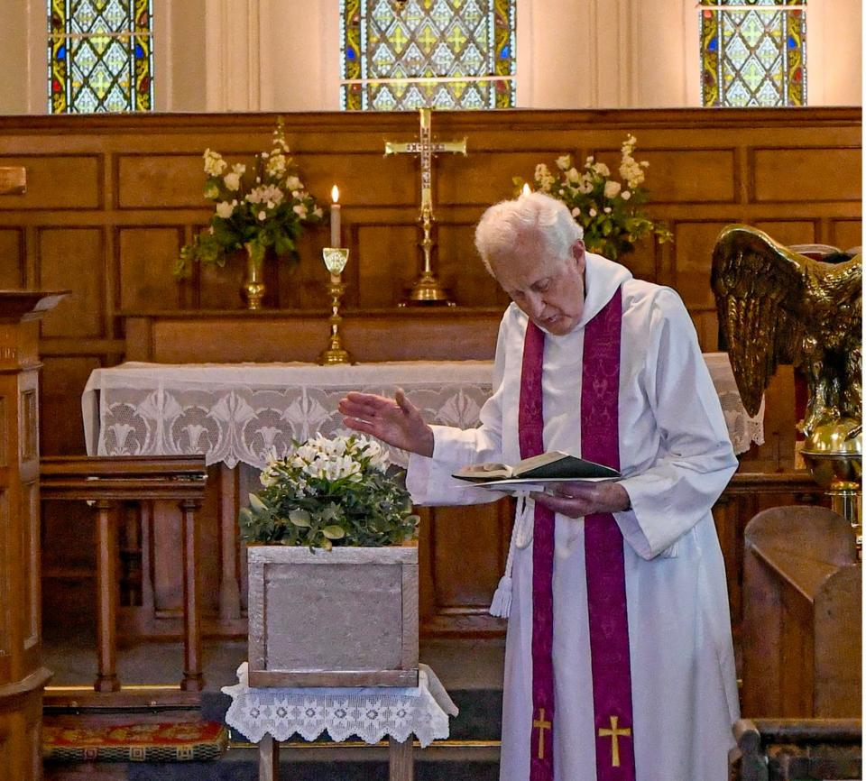 Reverend Gordon Wynne blessing the unknown man's coffin inside St Mary's Church