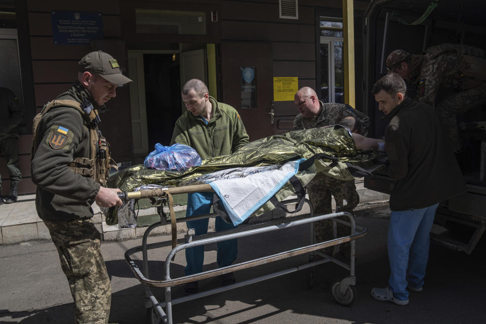 Ukrainian military medics transport an injured Ukrainian serviceman in Donetsk region, eastern Ukraine, Sunday, April 24, 2022. (AP Photo/Evgeniy Maloletka)