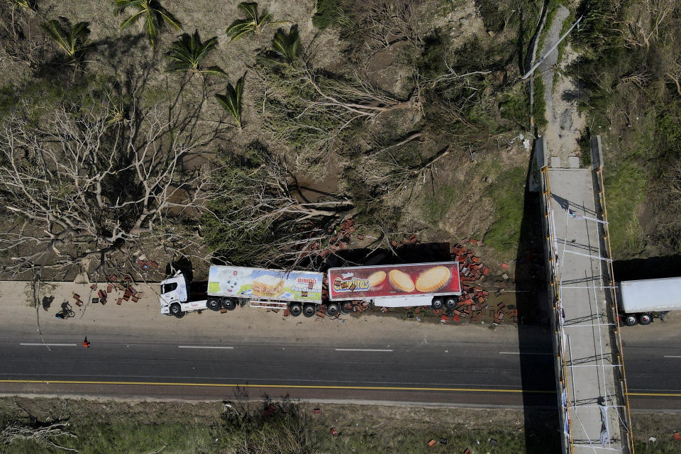An overturned semi lays on the shoulder of a highway in the aftermath of Hurricane Otis, on the outskirts of Acapulco, Mexico, Friday, Oct. 27, 2023. (AP Photo/Felix Marquez)