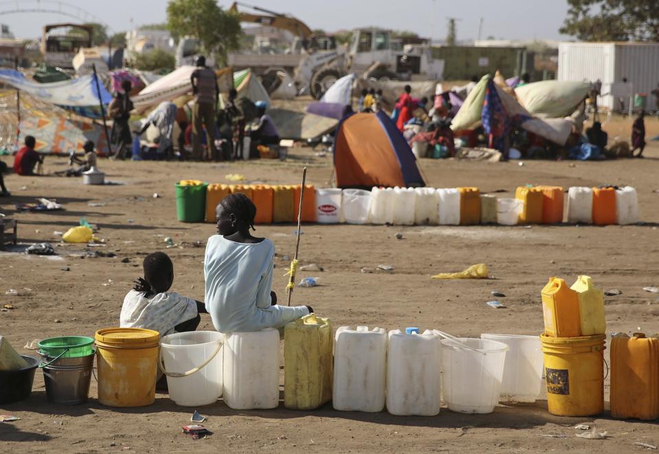 Internally displaced children wait for water inside a UNMIS compound in Juba
