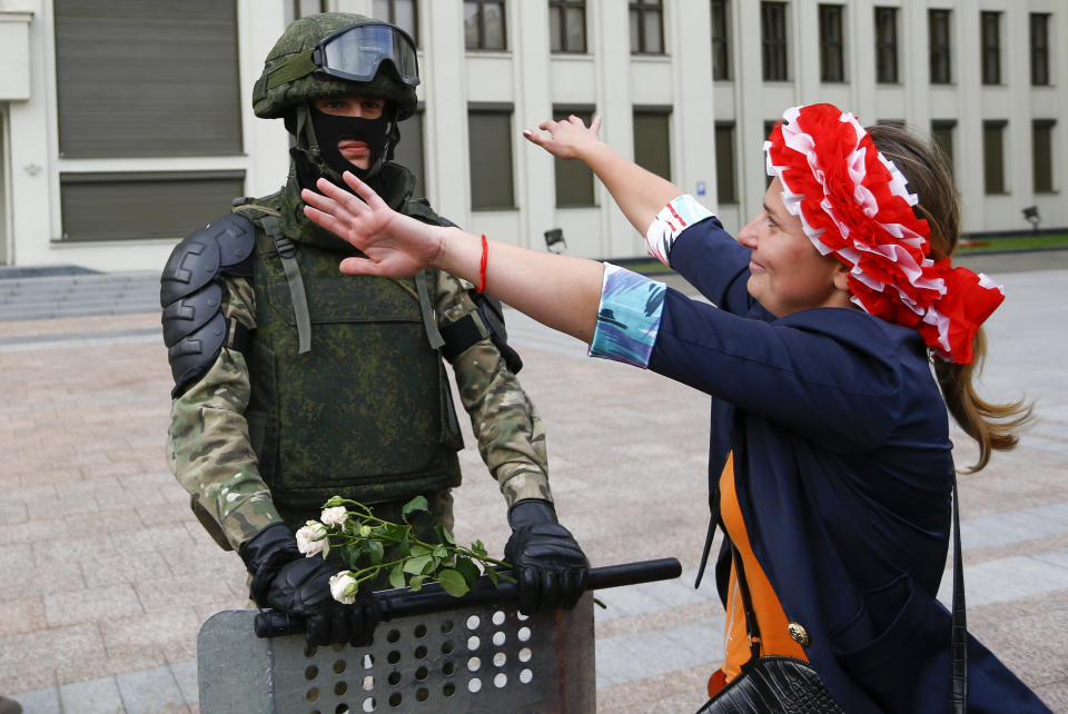 FILE - In this file photo taken on Friday, Aug. 14, 2020, a woman embraces a soldier guarding the Belarusian Government building in Minsk, Belarus. Tens of thousands of people have flooded the heart of the Belarus capital of Minsk in a show of anger over a brutal police crackdown this week on peaceful protesters that followed a disputed election. A former Soviet republic on the fault line between Russia and Europe is boiling with revolt this summer. Sounds familiar — but Belarus 2020 isn’t Ukraine 2014, and that’s why it’s hard to predict what will happen next. (AP Photo/Sergei Grits, File)