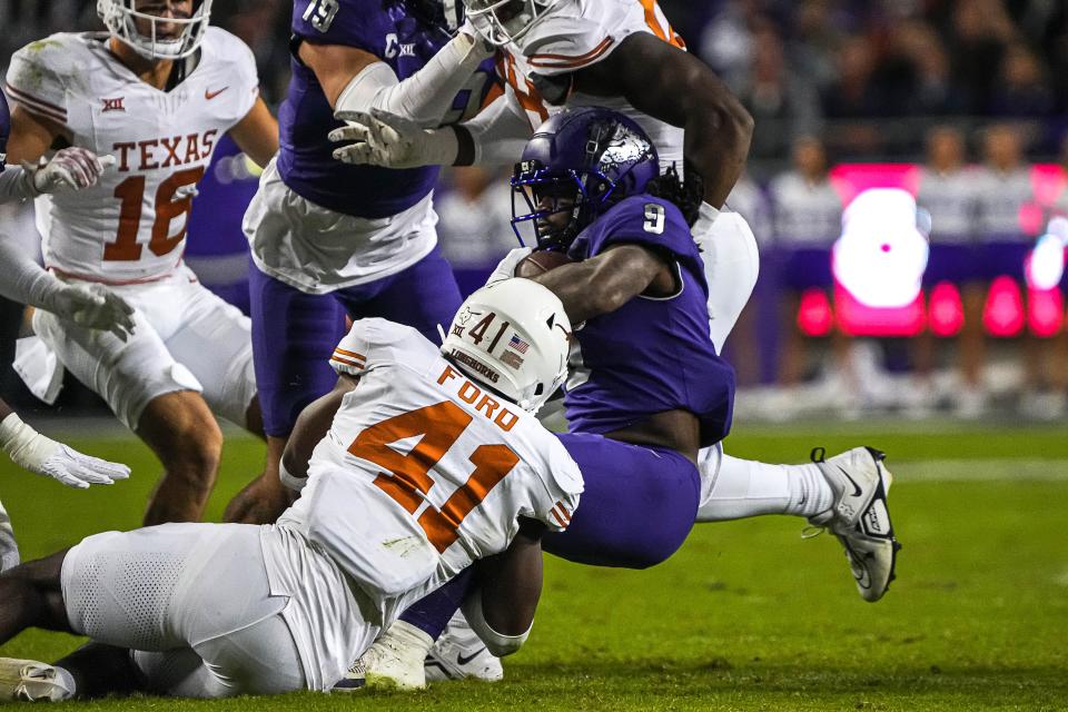 Jaylan Ford brings down TCU running back Emani Bailey on Nov. 11. The Longhorns are 10-1 and hoping for a spot in the College Football Playoff.