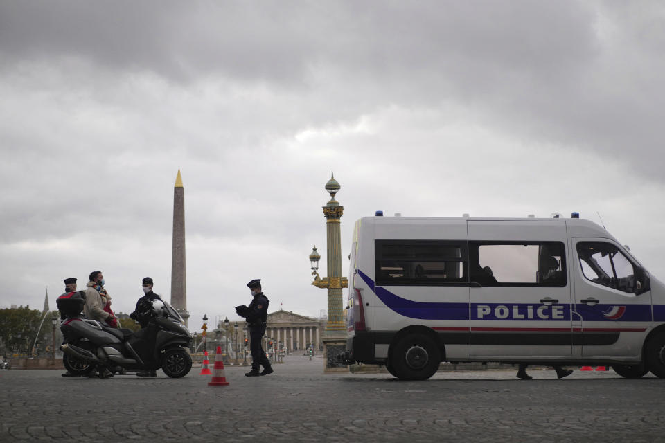 Police officers control a scooter in Paris, Friday, Oct. 30, 2020. France re-imposed a monthlong nationwide lockdown Friday aimed at slowing the spread of the virus, closing all non-essential business and forbidding people from going beyond one kilometer from their homes except to go to school or a few other essential reasons. (AP Photo/Thibault Camus)