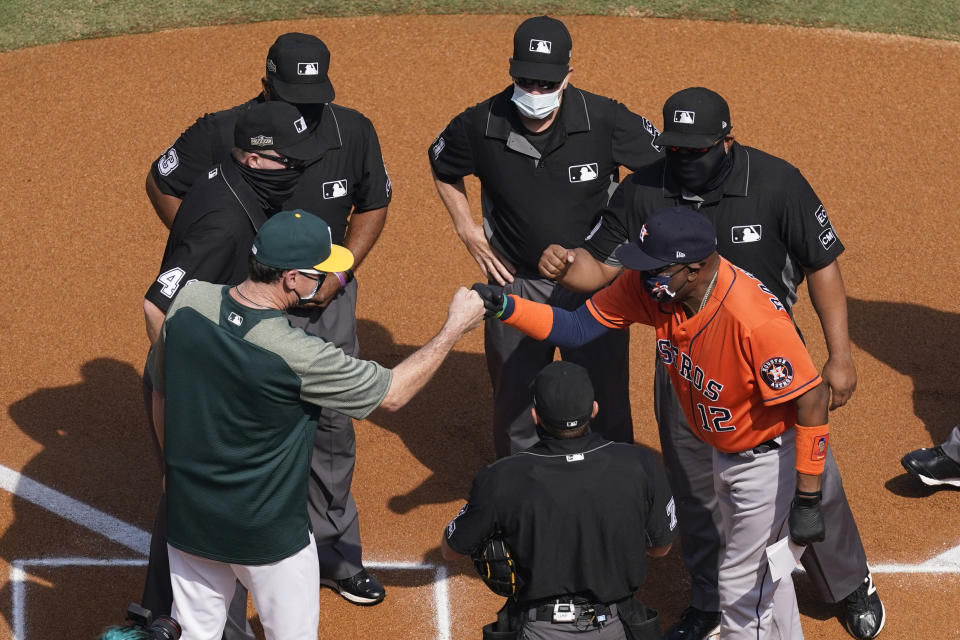 Oakland Athletics manager Bob Melvin, left, greets Houston Astros manager Dusty Baker Jr. as they meet with the umpire crew before Game 1 of a baseball American League Division Series between the teams in Los Angeles, Monday, Oct. 5, 2020. (AP Photo/Ashley Landis)