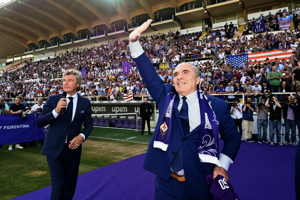 FILE - In this Friday, June 7, 2019 filer, Rocco Commisso, right, is flanked by former soccer star Giancarlo Antognoni as he waves to supporters at the Artemio Franchi stadium in Florence, Italy. Less than six months into his tenure as Fiorentina owner and president, Rocco Commisso is already starting to grapple with Italy’s infamous bureaucracy as he attempts to build a new stadium for the club. First, Commisso’s plan to overhaul the existing Stadio Artemio Franchi was rejected by the city committee that protects monuments. Now he is awaiting approval to build a new ground, perhaps near the city’s airport. (Claudio Giovannini/ANSA via AP, File )