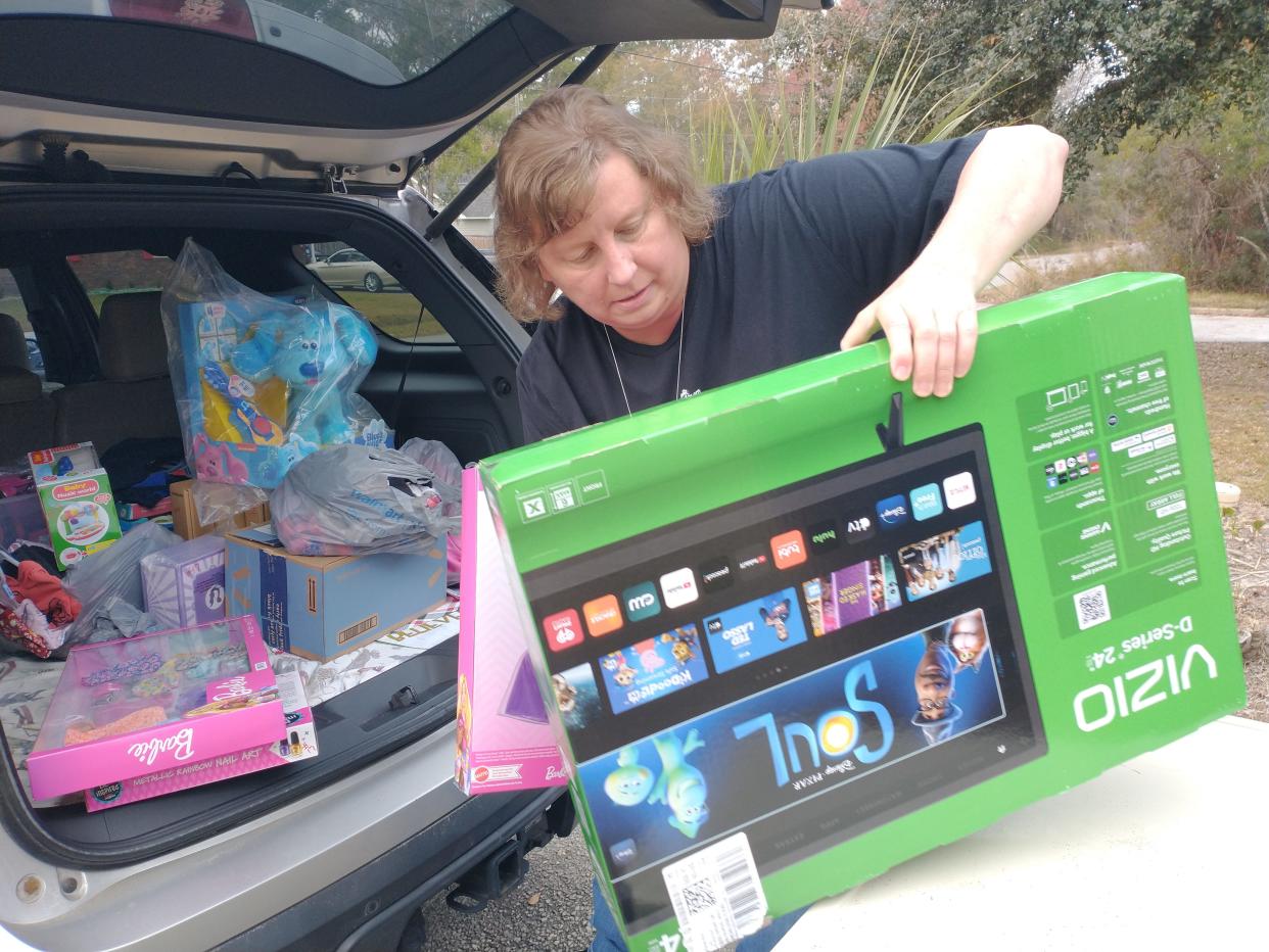 Ginger Harriott Hadwin, sister of the late Gloria Harriott Satterfield, unloads Christmas gifts purchased and donated by the Gloria's Gift Foundation.