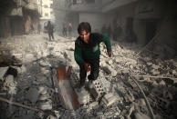 <p>A Syrians youth runs following an air strike in the rebel-held enclave of Arbin in the Eastern Ghouta near Damascus on Feb. 8, 2018.<br> (Photo: Amer Almohibany/AFP/Getty Images) </p>