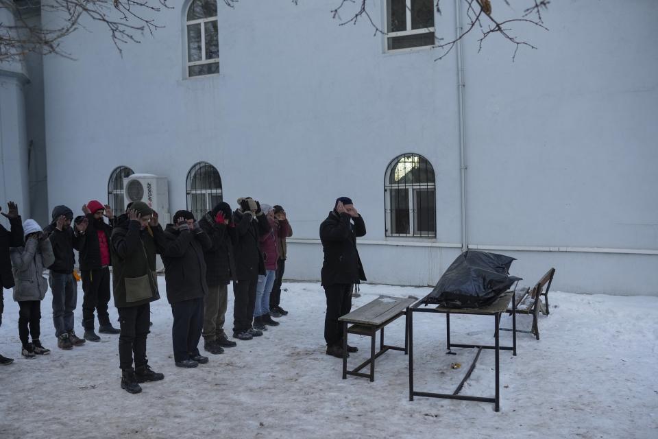 Men pray during the funeral of Syrian refugee Naziha Al-Ahmad after she died during an earthquake, in Elbistan, southeastern, Turkey, Friday, Feb. 10, 2023. Rescuers pulled several earthquake survivors from the shattered remnants of buildings Friday, including some who lasted more than 100 hours trapped under crushed concrete after the disaster slammed Turkey and Syria. (AP Photo/Francisco Seco)