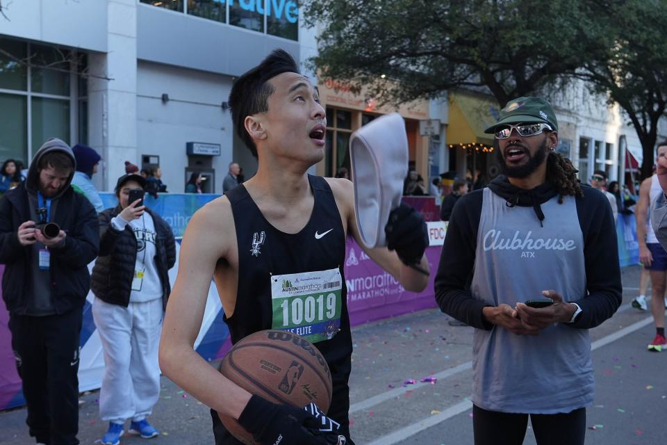 Ben Duong celebrates his setting a new Guinness Book of World Records mark for continuously dribbling a ball while running a half marathon. The former McNeil High School runner broke the previous world mark by about four minutes. "Without a doubt, I'll remember it forever," he said.