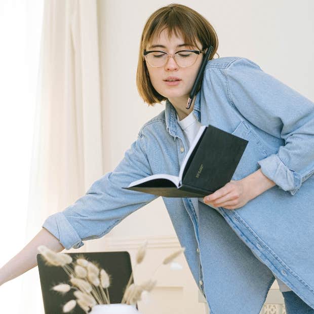 busy woman on the phone looking at book