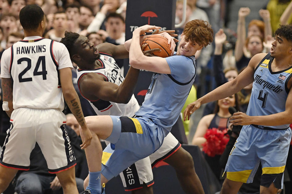 UConn's Adama Sanogo, left, and Marquette's Ben Gold, right, fight for a rebound in the first half of an NCAA college basketball game, Tuesday, Feb. 7, 2023, in Hartford, Conn. (AP Photo/Jessica Hill)