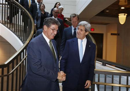 U.S. Secretary of State John Kerry (R) shakes hands with U.S. Senator Joe Manchin as they arrive on Capitol Hill before Kerry briefs members of the Senate Banking Committee behind closed doors about Iran and his recent negotiations in Europe, in Washington November 13, 2013. REUTERS/Larry Downing