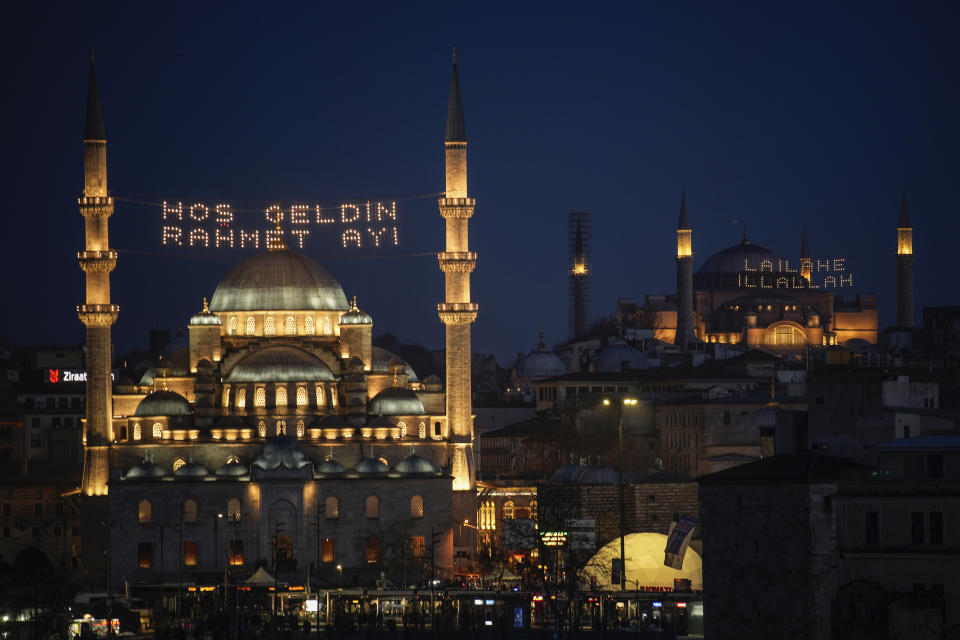 Light messages installed in the Yeni mosque, or New mosque, left, read in Turkish "Welcome month of mercy," and in Hagia Sophia mosque "There is no God but Allah" ahead of the Muslim holy month of Ramadan, in Istanbul, Turkey, Sunday, March 10, 2024. (AP Photo/Emrah Gurel)
