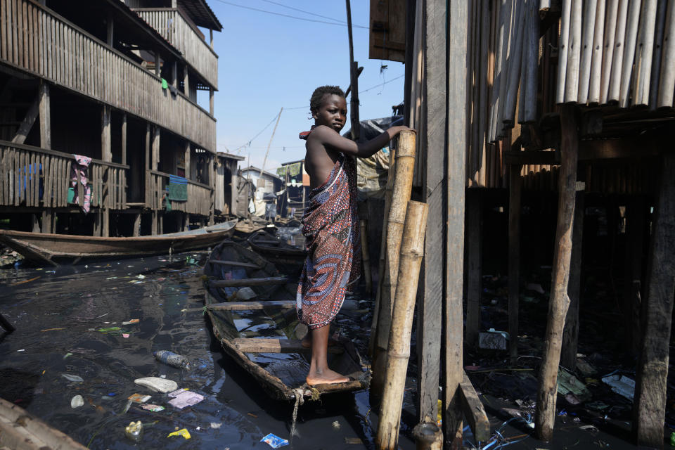 A child stands in filthy water surrounded by garbage in Nigeria's economic capital Lagos' floating slum of Makoko, Monday, March. 20, 2023. March 22 is World Water Day, established by the United Nations and marked annually since 1993 to raise awareness about access to clean water and sanitation. (AP Photo/Sunday Alamba)