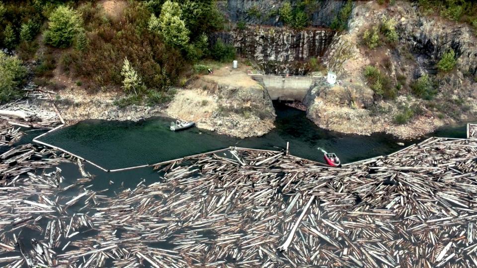 A boat holds back logs near the entrance of a drainage tunnel that acts as a relief valve, keeping Spirit Lake from cresting a dam formed by debris left from the 1980 Mt. St. Helens eruption.