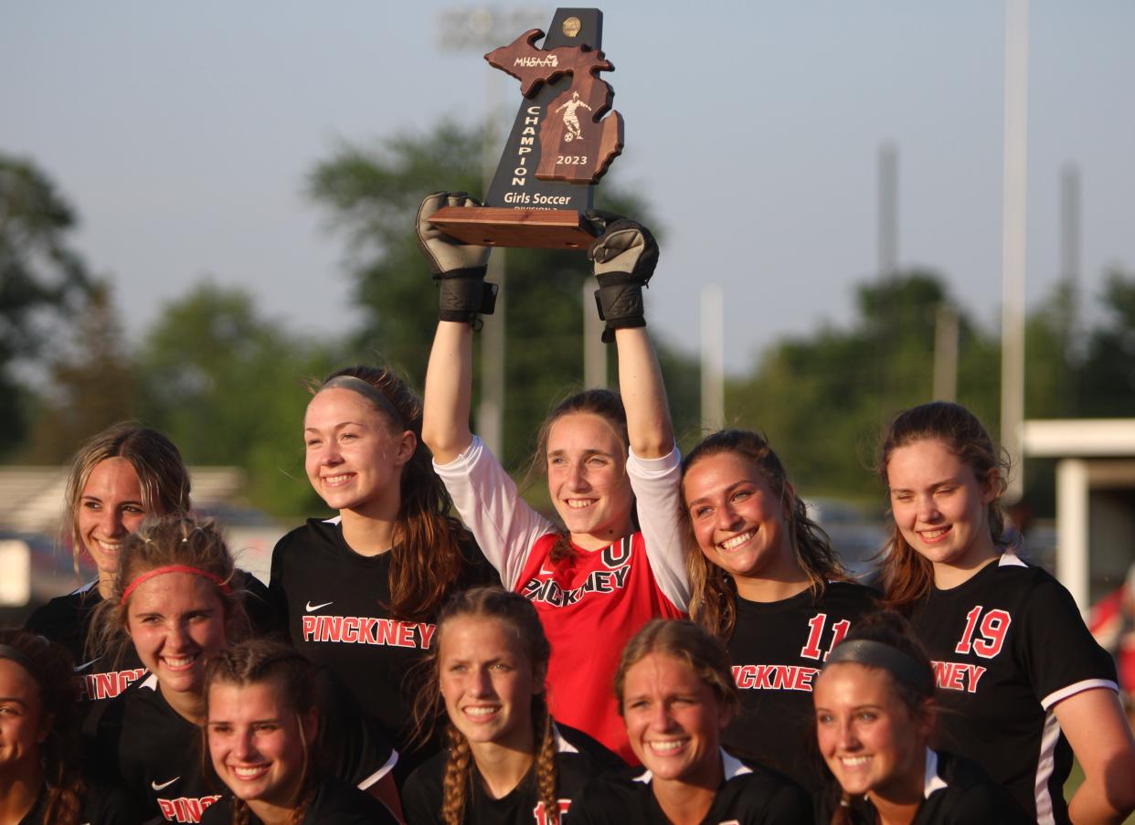 Pinckney goalie Peyton Delongchamp hoists the district championship trophy during the team photo taken following a 2-0 soccer victory over Jackson on Thursday, June 1, 2023 at Adrian.