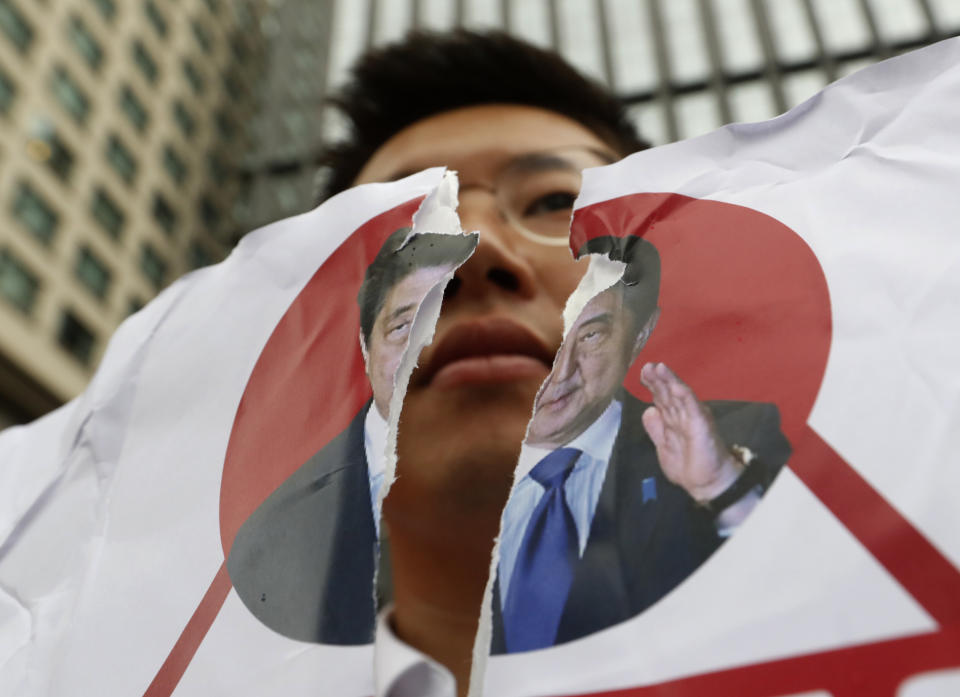 A protester holds a defaced image of Japanese Prime Minister Shinzo Abe during a rally denouncing the Japanese government's decision on their exports to South Korea in front of the Japanese Embassy in Seoul, Wednesday, July 17, 2019. In his strongest comments yet on a growing trade dispute, South Korean President Moon Jae-in urged Japan on Monday to lift recently tightened controls on high-tech exports to South Korea, which he said threaten to shatter the countries' economic cooperation and could damage Japan more than South Korea. (AP Photo/Ahn Young-joon)