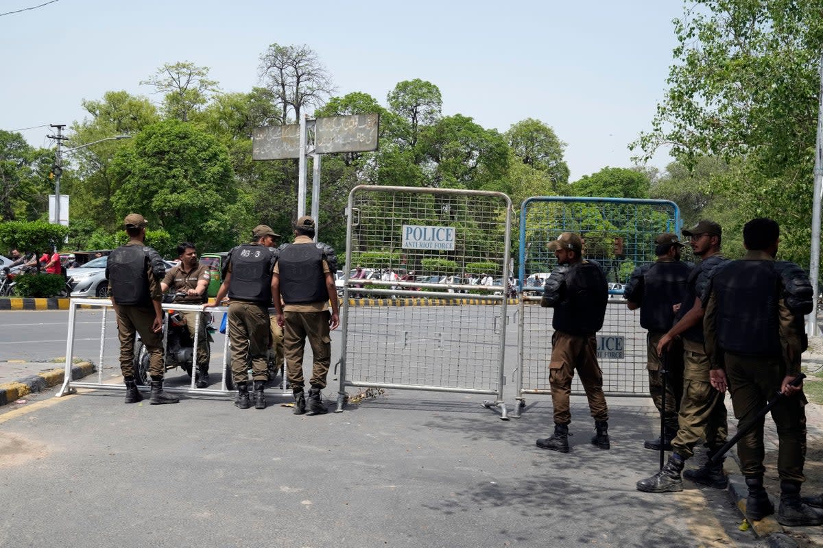 Pakistani security officials close a road outside the former Prime Minister Imran Khan's residence in Lahore on 18 May (AP)