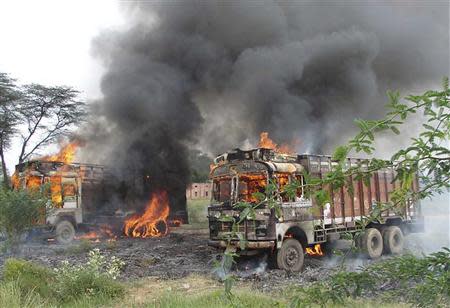 Smoke rises as vehicles burn after they were set on fire by a mob which was protesting against the ferrying of beef in the northern Indian state of Haryana August 30, 2013. REUTERS/Stringer