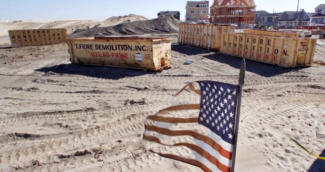 Superstorm Then And Now (This Oct. 13, 2013 photo shows a tattered flag flaping in the wind in Brick, N.J., where 60 small bunga