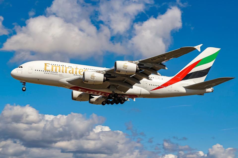 <p>Nicolas Economou/NurPhoto via Getty</p> Emirates Airbus A380 aircraft flying in the sky. 