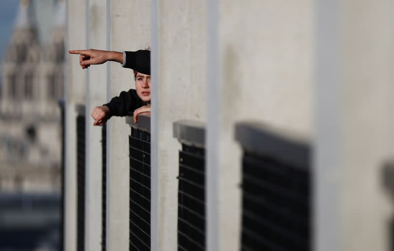 Visitors look out from the Viewing Level towards a luxury block of flats from the Tate Modern gallery in London