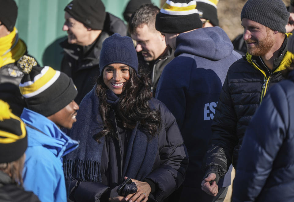 Prince Harry, right, and Meghan Markle, the Duke and Duchess of Sussex, speak with a skeleton athlete while attending an Invictus Games training camp, in Whistler, British Columbia, Thursday, Feb. 15, 2024. Invictus Games Vancouver Whistler 2025 is scheduled to take place from Feb. 8 to 16, 2025 and will for the first time feature winter sports. (Darryl Dyck/The Canadian Press via AP)