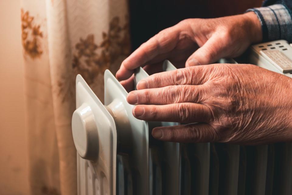 elderly person's hands on heater