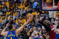 Denver Nuggets forward Michael Porter Jr., left, and Miami Heat center Bam Adebayo reach for the ball during the first half of Game 1 of basketball's NBA Finals, Thursday, June 1, 2023, in Denver. (AP Photo/Jack Dempsey)