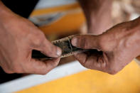 A worker re-connects a broken film strip before a wedding party in Bogor, Indonesia, February 18, 2017. REUTERS/Beawiharta