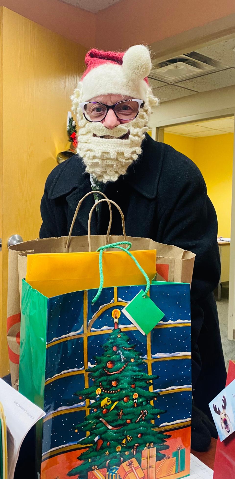 Joan Sprague, a volunteer for Faith in Action, plays Santa Claus as she prepares to deliver gifts to program participants.
