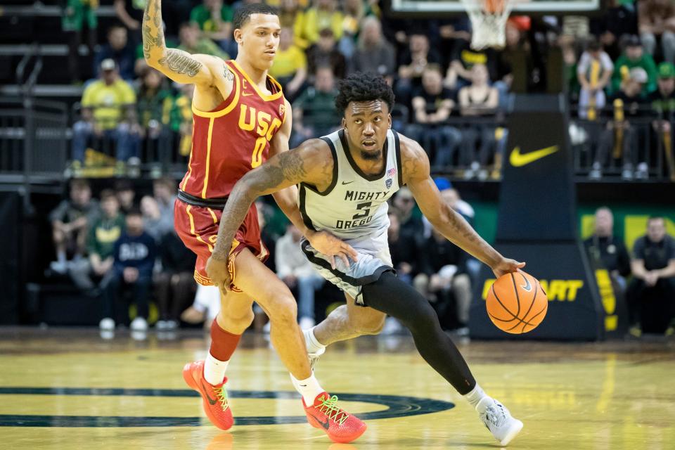 Oregon guard Jermaine Couisnard drives around USC guard Kobe Johnson as the Oregon Ducks host the USC Trojans Dec. 28 at Matthew Knight Arena in Eugene.