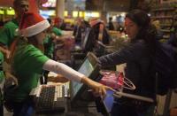 An employee points to the touch pad for a customer to check out at a Toys"R"Us store during their Black Friday Sale in New York November 28, 2013. REUTERS/Carlo Allegri