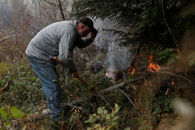 Steven Richardson, part of the Hillbilly Brigade of some 1,200 men and women who spontaneously came together to fight fires, works on a hot spot during the aftermath of the Riverside Fire near Molalla, Oregon