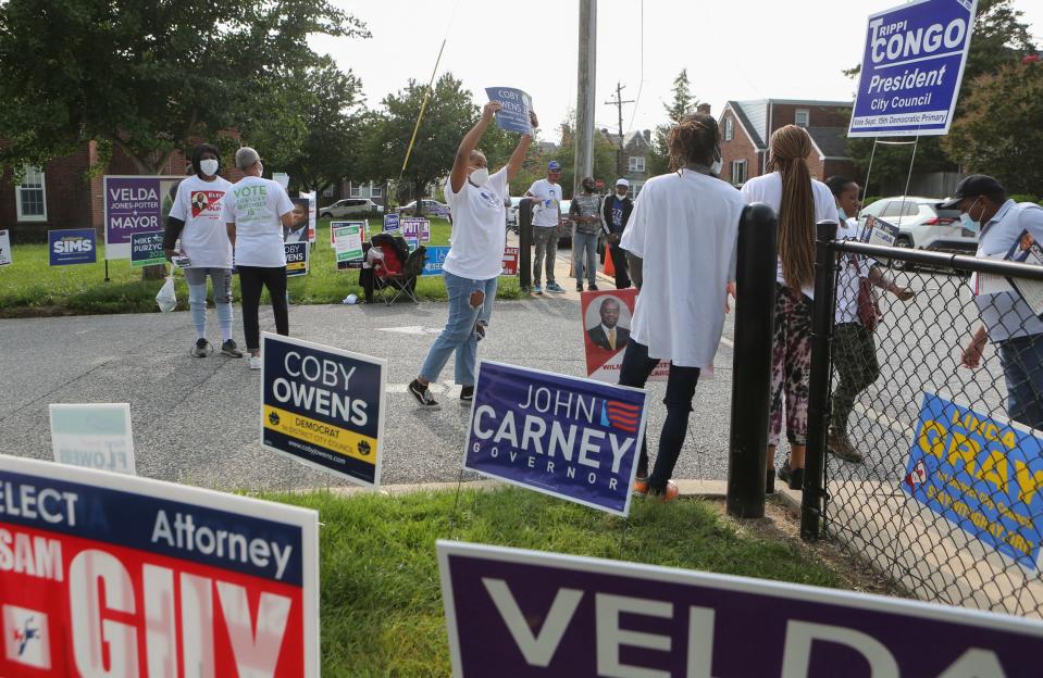 Primary election voters are greeted by candidates, campaigners and the usual proliferation of campaign signs at Harlan Elementary School in Wilmington on July 7, 2020.